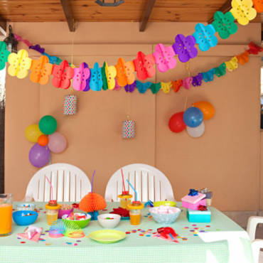 a table under a pergola covered with party decor