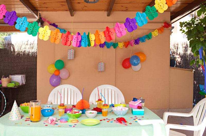 a table under a pergola covered with party decor