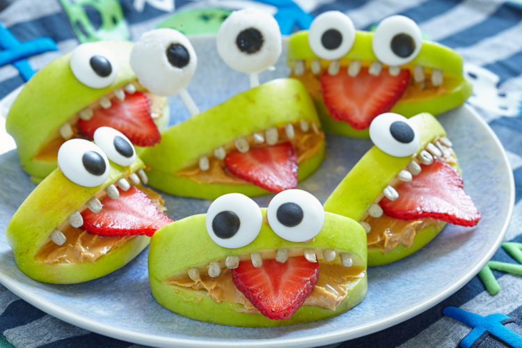 party food ideas with apple wedges made to look like cute monsters with sugar eyes and strawberry tongues