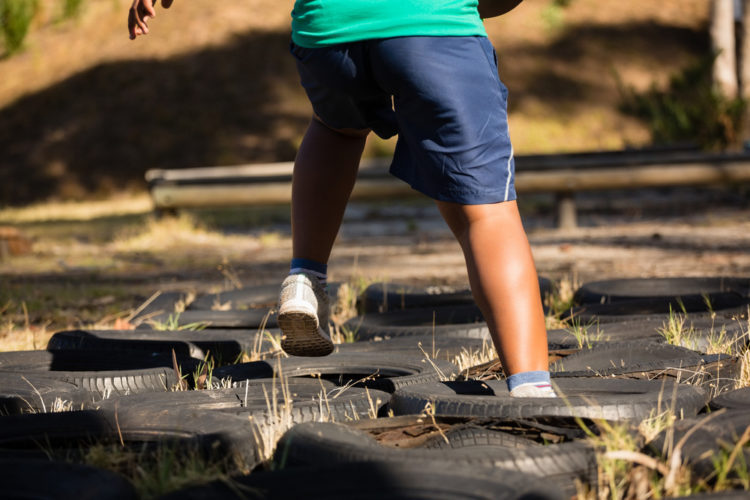 child running through tyres laid out on the ground