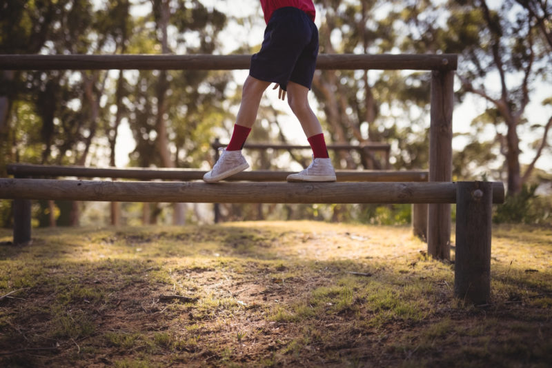 child balancing on outdoor beam