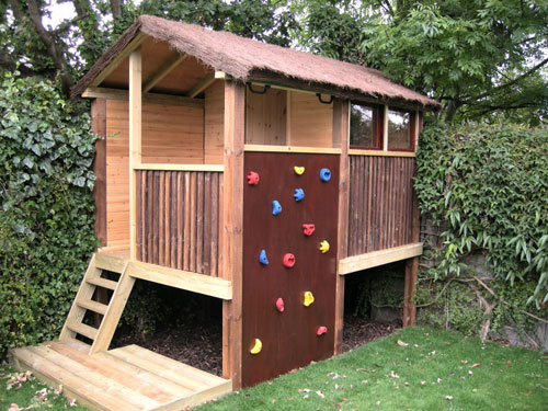 kids garden play area ideas featuring a treehouse with climbing wall