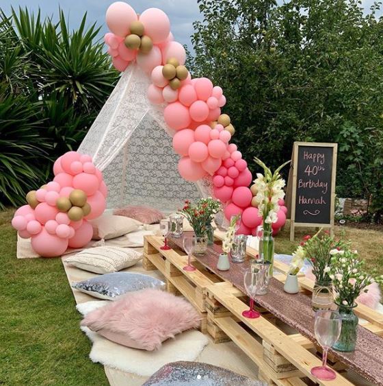 a lace tent at the head of a table, covered in balloons