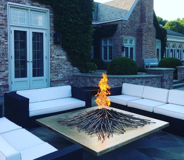 29 Garden Fire Pit Ideas for Cosy Evening Get-Togethers 28 a futuristic square fire pit with stylised metal twigs