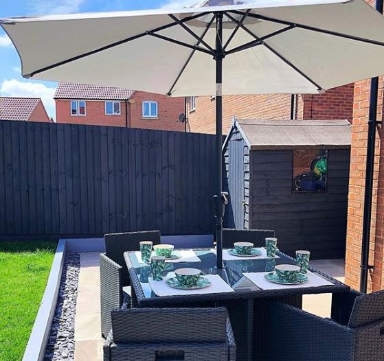 40 Garden Shed Ideas for Pretty to Practical Outdoor Buildings 20 a dark grey shed painted to blend in with a dark grey garden fence