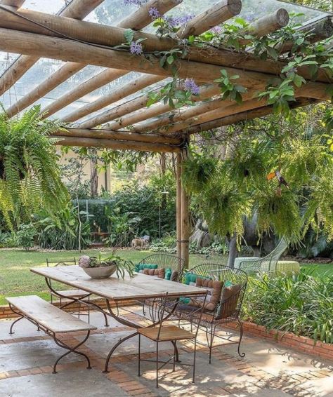 an open pergola above a patio dining set with lots of plants