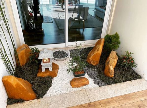 a small japanese style zen garden in a garden alcove