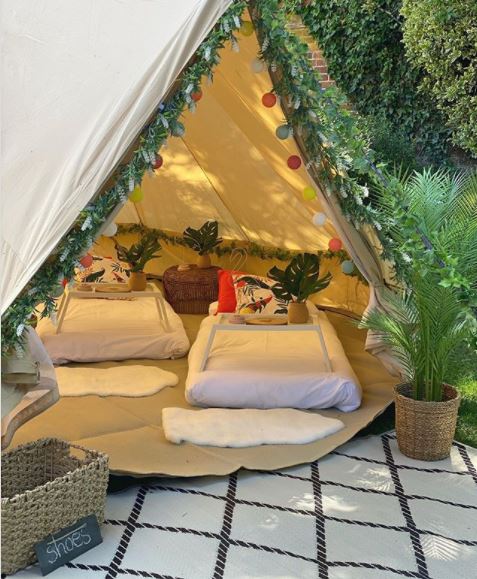 20 Fun & Adventurous Garden Camping Ideas For the Family 17 a peek inside a cosy bell tent with mattresses, rugs and artificial plant wreaths as decorations