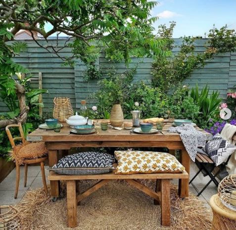 wooden patio furniture with cushions and table settings