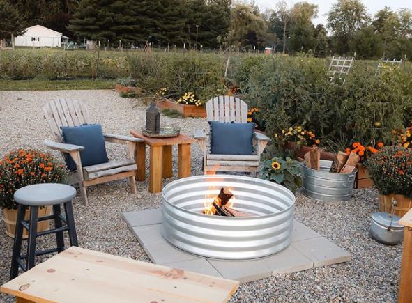 29 Garden Fire Pit Ideas for Cosy Evening Get-Togethers 23 garden furniture arranged around a DIY metal fire pit