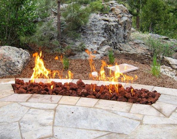 29 Garden Fire Pit Ideas for Cosy Evening Get-Togethers 10 a gas powered fire pit coming out of a patio floor