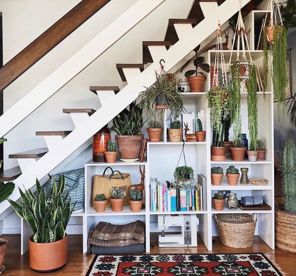 under stair shelves filled with books and plants