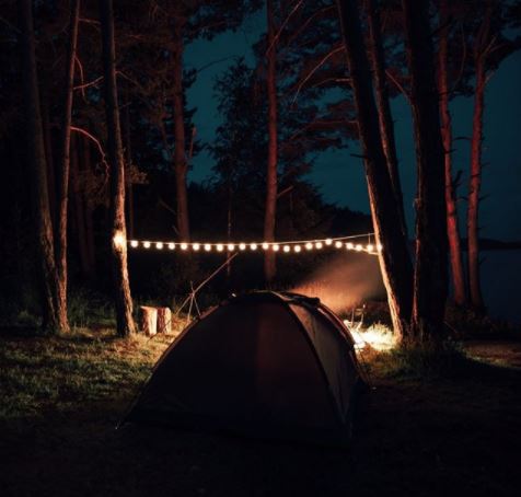20 Fun & Adventurous Garden Camping Ideas For the Family 2 two tents at night, with a bright string of lantern lights between them