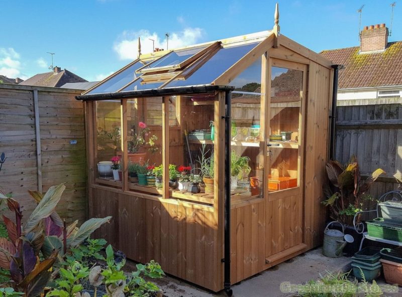 40 Garden Shed Ideas for Pretty to Practical Outdoor Buildings 6 a potting shed with windows along one side filled with plants