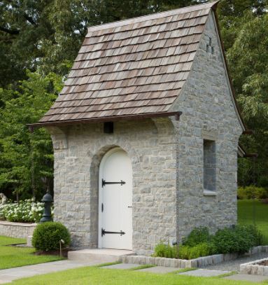 40 Garden Shed Ideas for Pretty to Practical Outdoor Buildings 36 a small stone shed with a white old-fashioned door and tiled roof