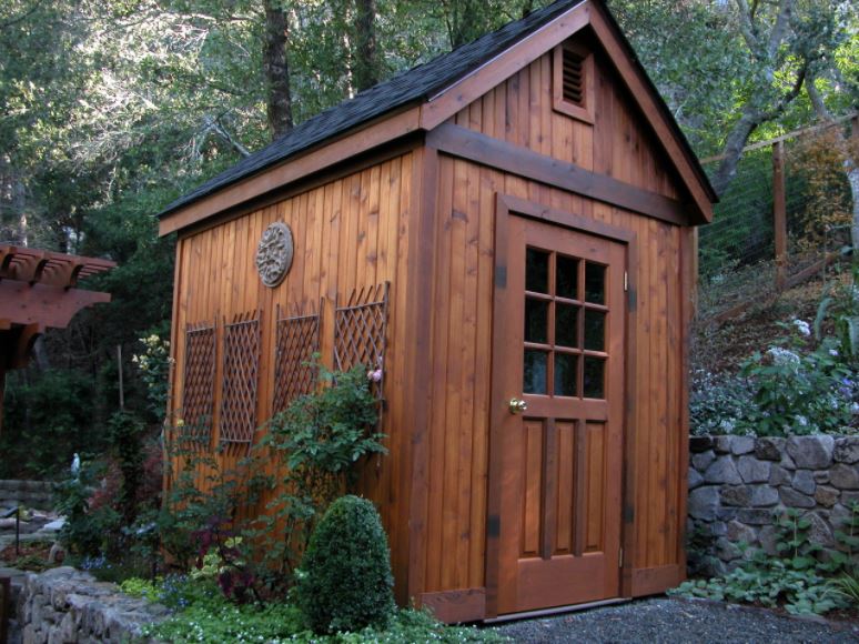 40 Garden Shed Ideas for Pretty to Practical Outdoor Buildings 12 a simple brown shed with a windowed door and trellises on the side