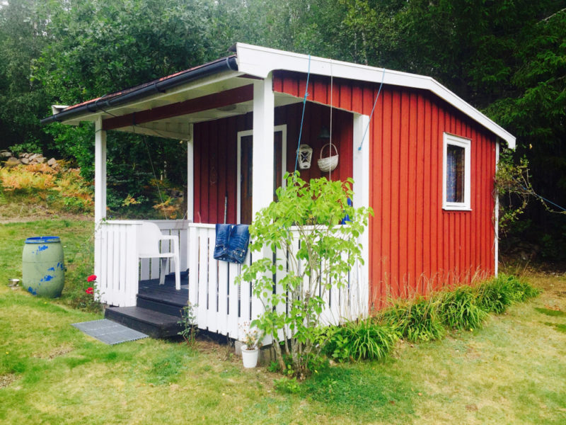 40 Garden Shed Ideas for Pretty to Practical Outdoor Buildings 3 a red-orange shed with a pretty white porch