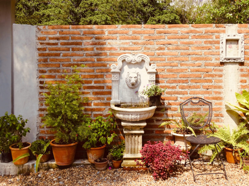 a wall-mounted stone fountain in the shape of a lion