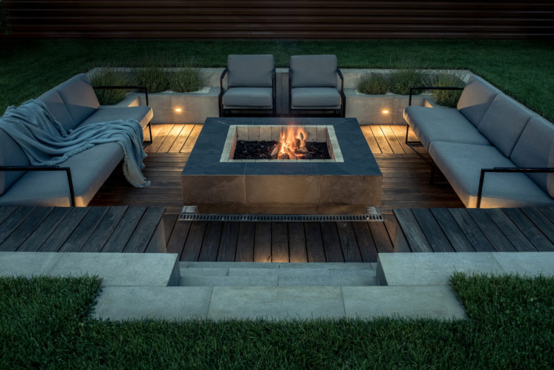 29 Garden Fire Pit Ideas for Cosy Evening Get-Togethers 26 a sleek square fire pit in a luxurious outdoor conversation pit