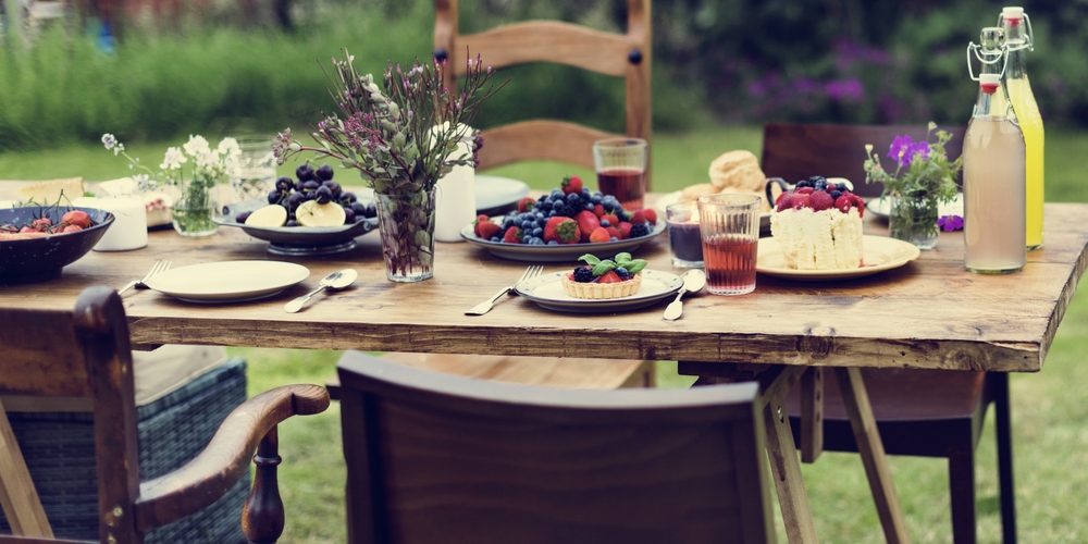 a garden party table laid out with fresh fruit desserts