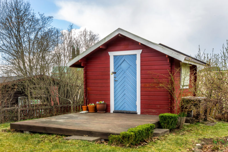 40 Garden Shed Ideas for Pretty to Practical Outdoor Buildings 4 a shed with a decking area in front of it