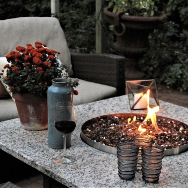 a small round fire pit in a stone topped coffee table