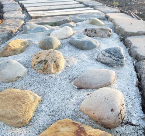 a concrete path with rocks embedded to create an uneven surface