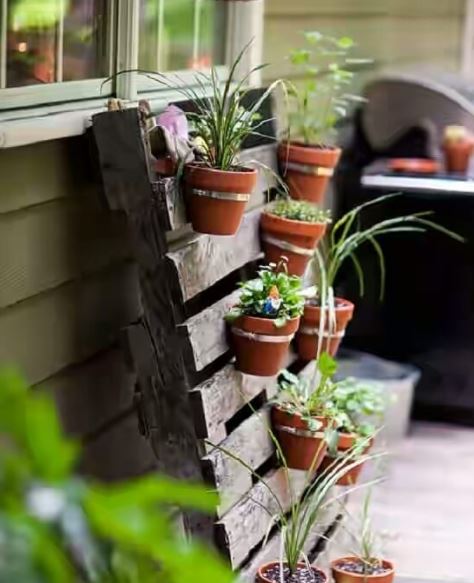 26 DIY Pallet Garden Ideas of Things to Make With Pallets 3 an untreated pallet with potted plants hanging from the slats