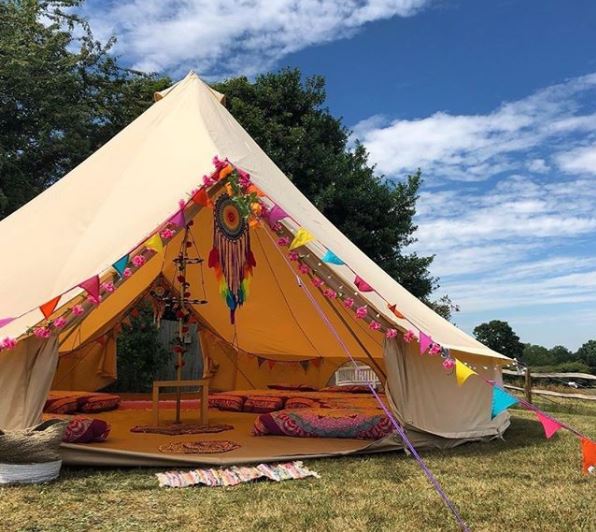 20 Fun & Adventurous Garden Camping Ideas For the Family 8 a large open bell tent with rainbow bunting and comfy mattresses with patterned blankets