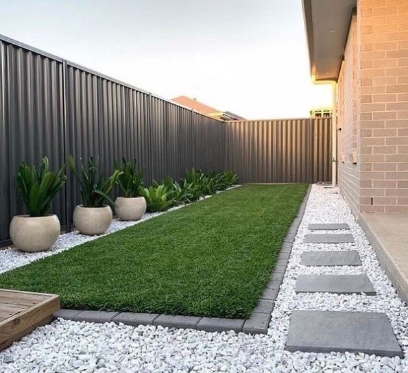 17 Long Garden Ideas to Design a Narrow Outdoor Area 13 a long narrow garden with grey fencing, stepping stones and crisp edging around the lawn