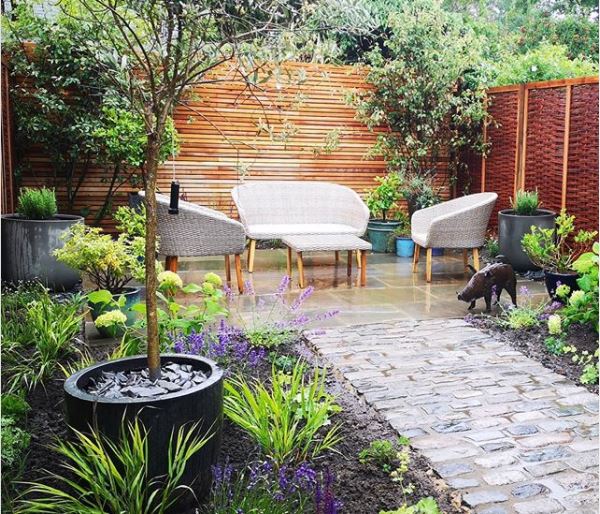 17 Long Garden Ideas to Design a Narrow Outdoor Area 10 a patio at the far end of a garden with lots of practical pots