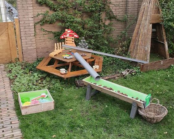 kids garden play area ideas using angled tubes with balls to play with gravity