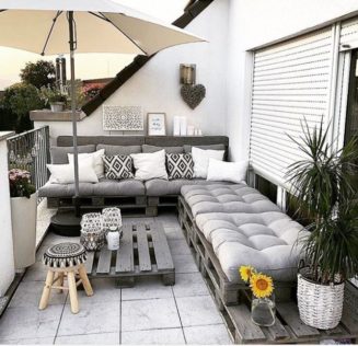 a rooftop garden with DIY pallet furniture, including a corner bench and coffee table