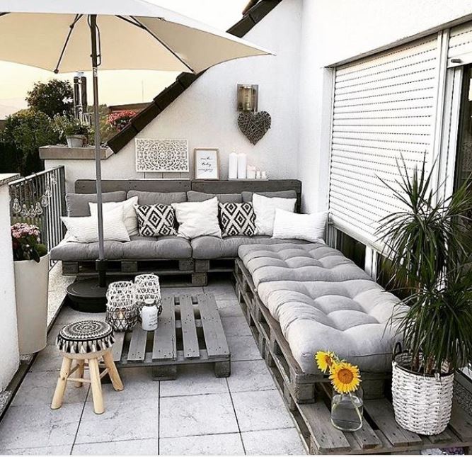 a rooftop garden with DIY pallet furniture, including a corner bench and coffee table