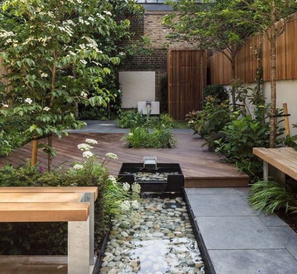 an urban garden with a raised deck and sunken water feature