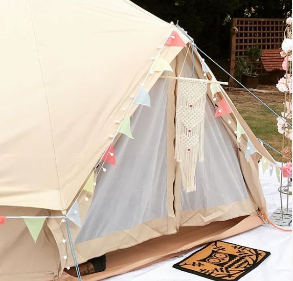 a canvas bell tent with pretty bunting lights and decor for garden camping