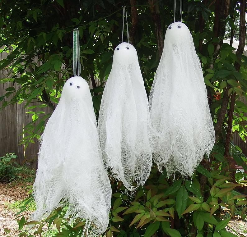 22 Halloween Garden Ideas: Fun & Low-cost Spooky Decorations 19 three ghosts made from lace and gauze, hanging from a branch as if they are floating