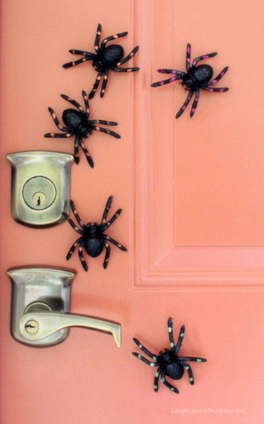 22 Halloween Garden Ideas: Fun & Low-cost Spooky Decorations 1 magnetic toy spiders clustered around the handle on a metal door