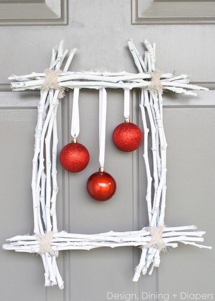 a square wreath framing three red baubles