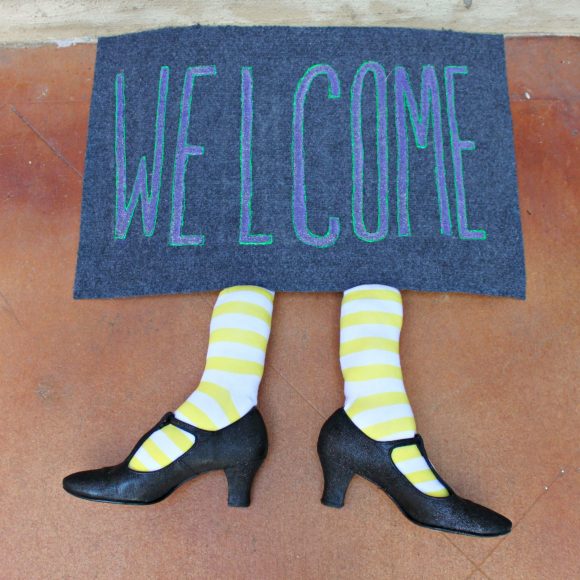 22 Halloween Garden Ideas: Fun & Low-cost Spooky Decorations 20 two stuffed socks and pointy shoes poking out from beneath a welcome door mat