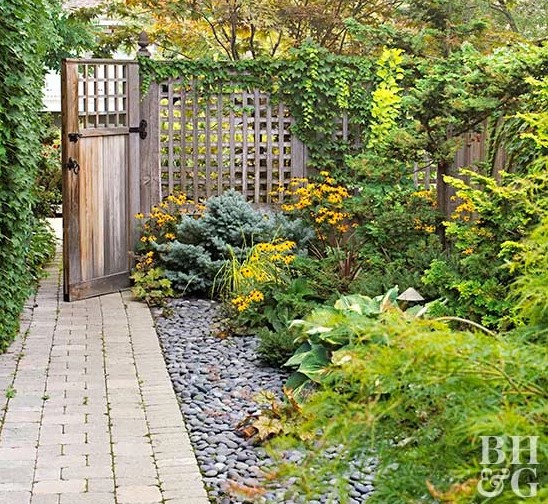 The Secret to a Manicured Landscape: 16 Garden Lawn Edging Ideas 6 a brick paved path next to a gravel-covered flower beds