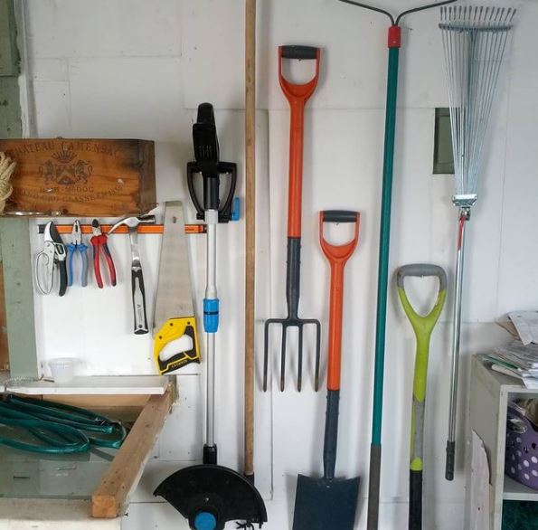 14 Garden Tool Storage Ideas: Keeping Your Shed Ship-Shape 6 a shed wall with various garden tools hanging on hooks