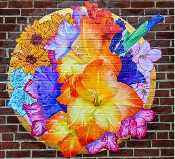 29 Unique Garden Mural Ideas for Outdoor Walls & Fences 20 a circular garden mural with brightly coloured painted flowers