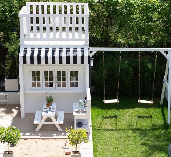 an elaborate playhouse designed to look like an ice-cream parlour, with an upper deck, picnic benches and striped awning