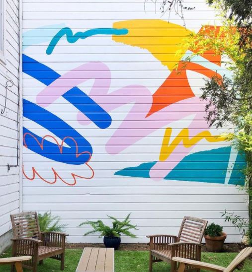 29 Unique Garden Mural Ideas for Outdoor Walls & Fences 10 a bright garden wall mural using retro shapes and a cheerful colour palette
