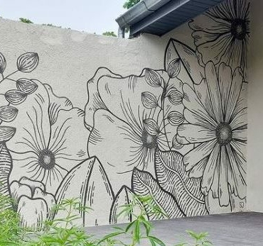 a black line drawing of flowers and leaves on a white garden wall