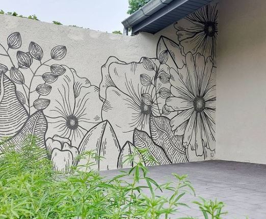 29 Unique Garden Mural Ideas for Outdoor Walls & Fences 14 a black line drawing of flowers and leaves on a white garden wall