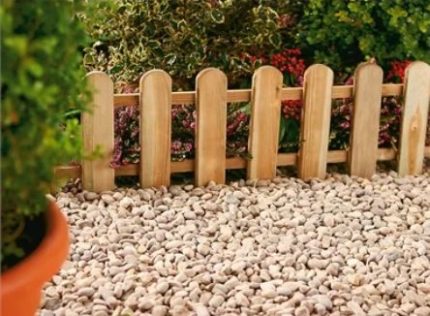 The Secret to a Manicured Landscape: 16 Garden Lawn Edging Ideas 8 a miniature wooden picket fence used as garden edging between flower beds and gravel