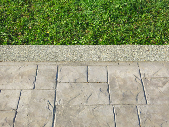 close up of a stamped concrete path next to a crisp lawn edge