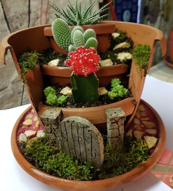 a broken pot reformed to create a fairy garden with several levels